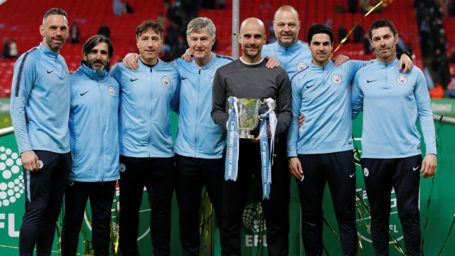 Pep Guardiola dan staf kepelatihan City berpose dengan trofi Piala Liga. Foto: Reuters/David Klein