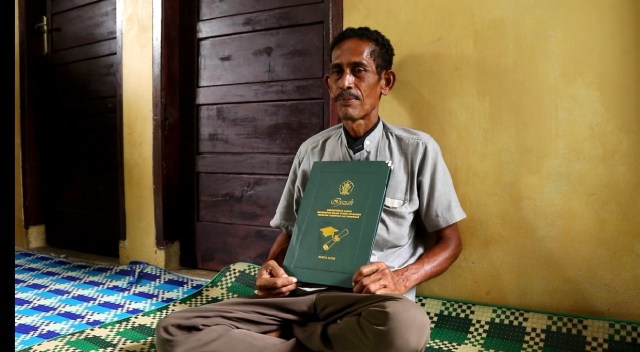 Bukhari, ayah almarhumah Rina memegang ijazah sebagai kenang-kenangan. Foto: Husaini Ende/acehkini