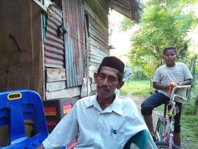 Ayah dari almarhumah Rina Muharami, Bukhari, bersama anak bungsunya saat dijumpai di kediamannya, Senin (4/3). Foto: Husaini Ende/acehkini