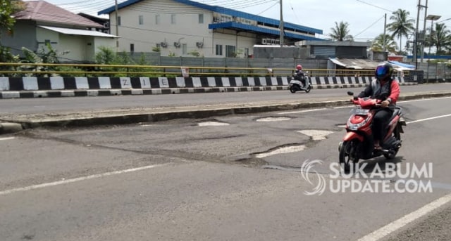 Pengendara motor menghindari lubang jalan di jalan Lingkar Selatan Sukabumi Foto: Sukabumiupdate