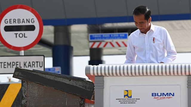 Presiden Joko Widodo membubuhkan tanda tangan ketika meresmikan tol Trans Sumatera ruas Bakauheni-Terbanggi Besar di Gerbang Tol Natar, Lampung Selatan, Lampung. Foto: Antara/Wahyu Putro A
