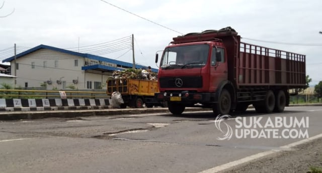 Kendaraan berat melintas di jalan lingkar selatan yang banyak ditemukan lubang dan kondisi permukaan aspal bergelombang. | Sumber Foto:Muhammad Gumilang.