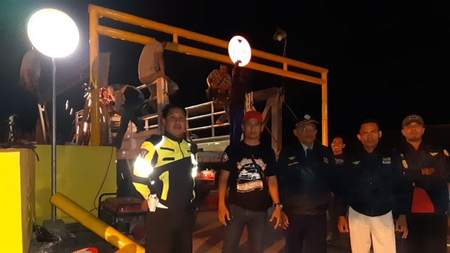 Personel Dishub Banjarmasin memasang portal dan menjaganya di Jembatan Seribu, Kelurahan Alalak, Banjarmasin. Foto: Zahidi/banjarhits.id