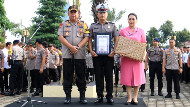 Anggota Satlantas Polres Kediri, Aiptu Sujadi (tengah) penyelamat keluarga korban banjir di jalan Tol Ngawi pada Jumat (8/3) lalu, menerima penghargaan. Foto: Dok. Istimewa