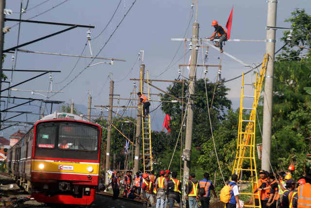 Pekerja memperbaiki jaringan Listrik Aliran Atas (LAA) pascakecelakaan KRL di kawasan Kebon Pedes, Bogor, Jawa Barat, Senin (11/3/2019). Foto: ANTARA FOTO/Yulius Satria Wijaya