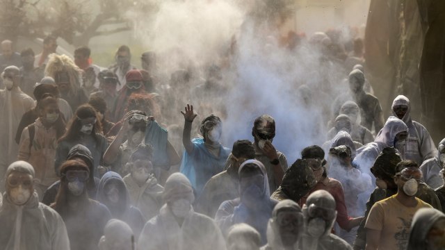 Pengunjung saling melemparkan tepung berwarna saat merayakan 'Ash Monday', dalam sebuah pesta tradisional yang menandai akhir musim karnaval dan awal periode 40 hari Prapaskah sampai Paskah Ortodoks, di Pelabuhan Galaxidi, Yunani. Foto: AFP/ARIS MESSINIS