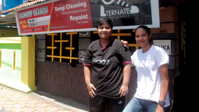 Kartini Hasan (Kaos Putih) bersama karyawannya, Ari saat berfoto di depan tempat usaha mereka, Ternate Shoes Cleaner di Kelurahan Soa-Sio Ternate, Maluku Utara. Foto: Rizal Syam/cermat 