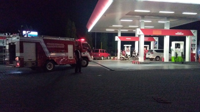 Petugas Dinas Damkar Kabupaten Bojonegoro, saat tiba di SPBU Medalem, Desa Prayungan Kecamatan Sumberrejo Bojonegoro, yang dikabarkan terbakar. Selasa (12/03/2019).