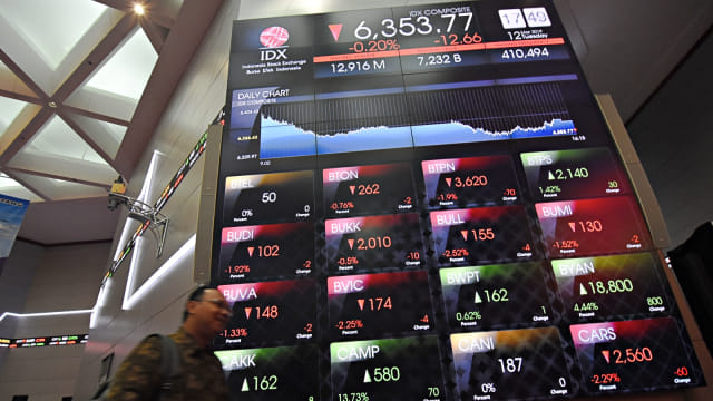 Karyawan melintas di dekat layar pergerakan saham di Bursa Efek Indonesia, Jakarta. Foto: Antara/Indrianto Eko Suwarso