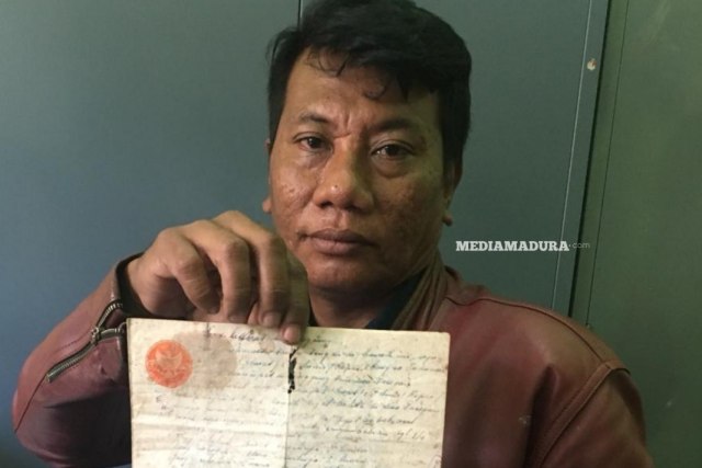 Taufik, pemilik tanah di bantaran sungai Kali Kamuning menunjukkan bukti kepemilikan lahan berupa Letter C saat dimintai klarifikasi di kantor Satpol PP Sampang, Rabu (13/3/2019). (Ryan Hariyanto/MM).