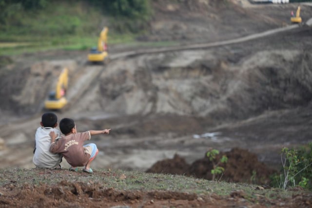 Dua anak melihat proses pembangunan jalan Tol Aceh di Montasik, Aceh Besar, Kamis (14/3). Foto: Suparta/acehkini 