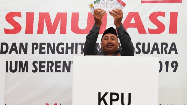 Seorang penyelenggara Pemilu 2019 menunjukan kertas suara sebelum melakukan pencoblosan di bilik suara saat simulasi pemungutan dan perhitungan suara pemilihan umum 2019 di Sumenep, Jawa Timur, Sabtu (16/3). Foto: ANTARA FOTO/Zabur Karuru