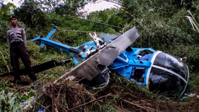 Petugas kepolisian berjaga di dekat helikopter B-105 PK EAH milik PT Air Transport Service yang jatuh di Desa Jayaratu, Kabupaten Tasikmalaya, Jawa Barat, Sabtu (16/3). Foto: ANTARA FOTO/Dok Basarnas