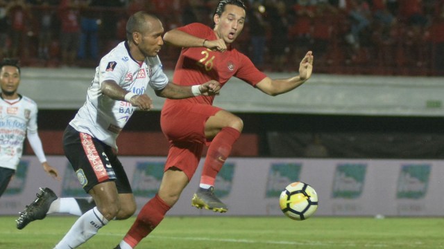 Pesepak bola Timnas U-23 Indonesia Ezra Walian (kanan) berebut bola dengan pesepak bola Bali United Leonard Tupamahu (kiri) saat pertandingan uji coba di Stadion Kapten I Wayan Dipta, Gianyar, Bali, Minggu (17/3). Foto: ANTARA FOTO/Fikri Yusuf