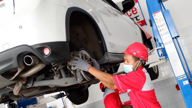Dua montir saat servis kaki-kaki mobil. Foto: Aditya Pratama Niagara/kumparanOTO
