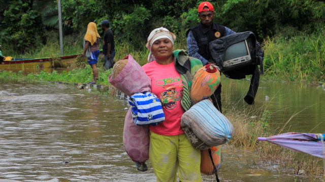 Warga mengamankan barang berharga dari rumahnya yang rusak akibat banjir bandang Sentani di Kampung Yoka, Jayapura, Papua, Selasa (19/3). Foto: ANTARA FOTO/Gusti Tanati