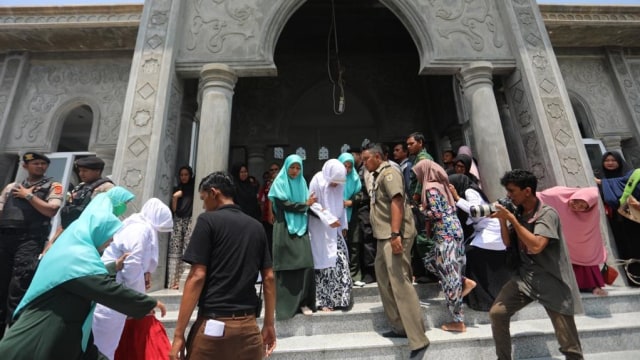 Petugas Wilayatul Hisbah mengawal terhukum cambuk perempuan, Rabu (20/3). Foto: Suparta/acehkini 