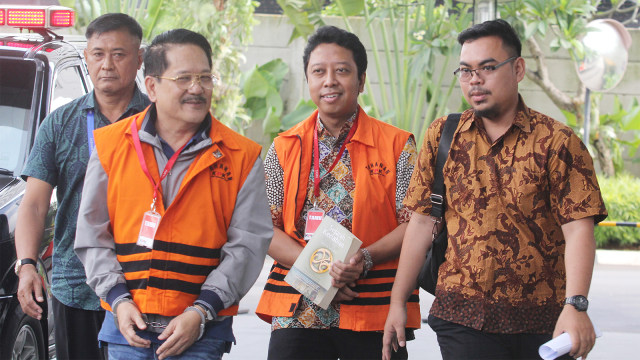 Tersangka Anggota DPR Fraksi PPP Nonaktif Romahurmuziy (kedua dari kanan) menutupi borgol dengan buku saat tiba di Gedung KPK. Foto: ANTARA FOTO/Reno Esnir