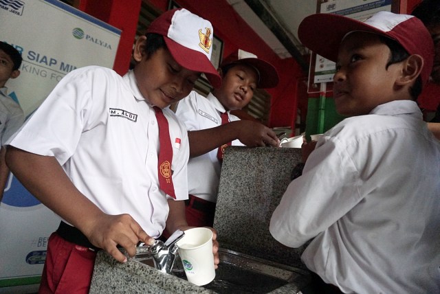 Siswa-siswa mengisi air minum lewat keran air dalam peluncuran penyediaan air siap minum di SDN 03 dan SDN 04 Penjaringan, Jakarta Utara, Jumat (22/3). Foto: Jamal Ramadhan/kumparan