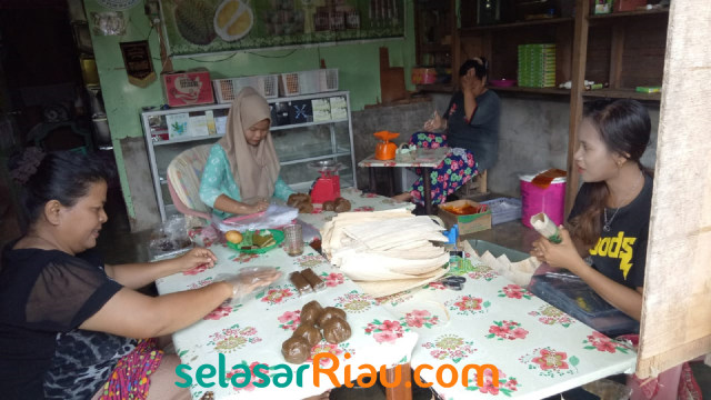 PARA pekerja sedang mengemas Lempuk Durian Khas Bengkalis ke dalam daun pelepah pinang tua yang sudah dijemur di bawah terik matahari, Sabtu, 23 Maret 2019, Selat Baru, Bengkalis.  