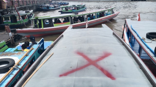 Petugas Dishub Banjarmasin memberi tanda silang atap klotok wisata karena membiarkan wisatawan duduk di atas atap. Foto: Zahidi/banjarhits.id