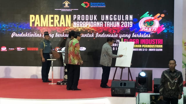 Wakil Presiden Jusuf Kalla (kanan) menulis angka 1 sebagai simbol pembukaan Pameran Produk Unggulan Narapidana 2019. Foto: Nadia Riso/kumparan