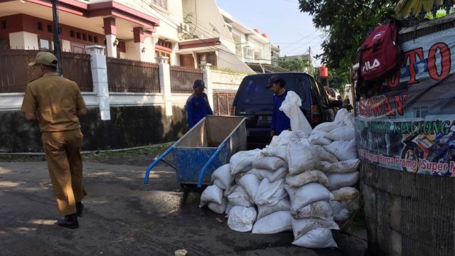 Suasana para petugas PU Jati Padang membersihkan barang-barang yang rusak karena banjir. Foto: Muhammad Darisman/kumparan