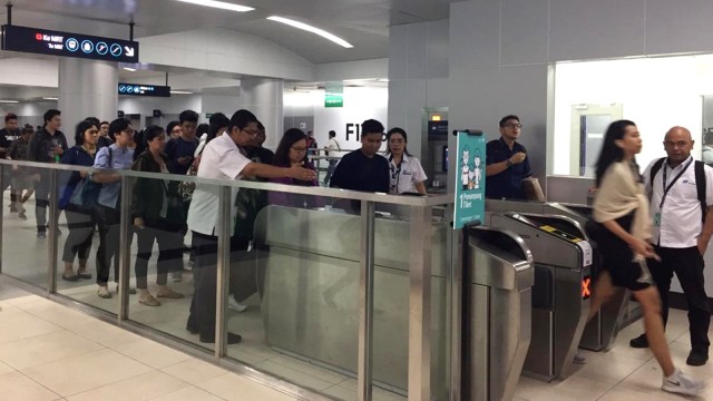 Petugas MRT bantu penumpang yang terkendala mesin tap in tap out yang kadang eror saat masuk ke Stasiun MRT. Foto: Lutfan Darmawan/kumparan