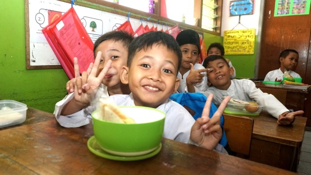 Sejumlah siswa mendapatkan makanan dari Program Pemberian Makanan Tambahan Anak Sekolah (PMTAS) di SDN Kedaung Kali Angke, Jakarta, Jumat (5/4). Foto: Nugroho Sejati/kumparan