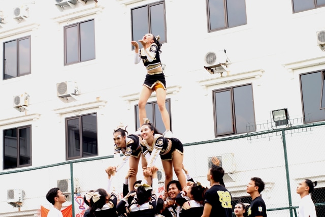 Terik matahari siang di Cikarang sangat menyengat. Namun, hal itu tidak menyurutkan semangat para pemandu sorak dari jurusan Business Administration ini (Foto: Mohammad Shihab).