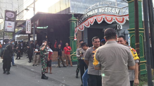 Polisi berjaga di Jalan Wates Km 8 Pedukuhan Ngaran, Desa Balecatur, Kecamatan Gamping, Kabupaten Sleman, Minggu (7/4). Foto: Arfiansyah Panji Purnandaru/kumparan