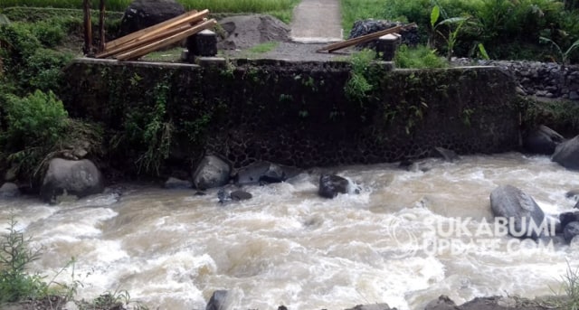Jembatan penghubung Kampung Sirnarasa, Desa Sirnarasa, dengan Kampung Ciptagelar, Desa Sirnaresmi, putus akibat diterjang derasnya aliran Sungai Cisarua, Minggu sore (7/4/2019). Tak nampak sisa-sisa dari badan jembatan karena seluruhnya hanyut. | Sumber Foto:Nandi.