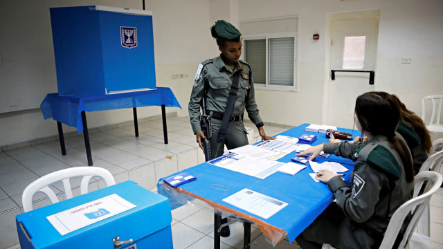 Seorang polisi wanita Israel bersiap untuk memilih di TPU. Foto: Reuters/Nir Elias
