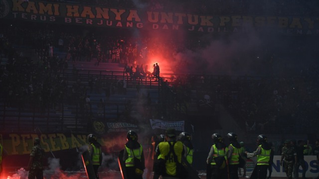 Sejumlah petugas keamanan berjaga-jaga ketika suporter Persebaya Surabaya menyalakan cerawat (flare) dan melempar botol minuman saat akhir laga final leg 1 Piala Presiden 2019 antara Persebaya Surabaya vs Arema FC di Gelora Bung Tomo, Surabaya, Jawa Timur, Selasa (9/4). Foto: ANTARA FOTO/Zabur Karuru