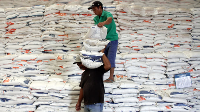 Pekerja mengangkut beras di Gudang Beras Bulog. Foto: ANTARA FOTO/Arnas Padda