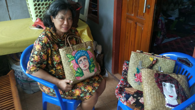 Naning dengan kreasi tas purun yang dipadukan dengan lukisan. Foto: Yovy Hasendra