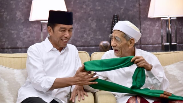 Mbah Moen memberikan serban untuk Joko Widodo sebelum menghadiri Konser Putih Bersatu di Stadion Utama GBK, Jakarta, Sabtu (13/4). Foto: Dok. Istimewa