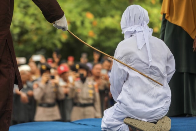 Seorang pelanggar syariat Islam menjalani hukuman cambuk di muka umum yang digelar di halaman Masjid Al-A'la Gampong Cot Mesjid, Lueng Bata, Kota Banda Aceh, Senin (15/4). Foto: Suparta/acehkini