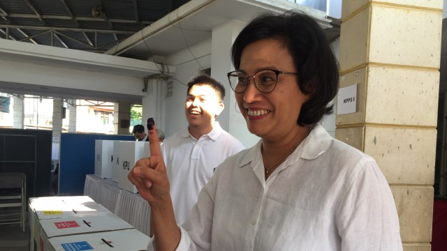 Menteri Keuangan Sri Mulyani Indrawati (kanan) menunjukan jarinya setelah menggunakan hak pilihnya. Foto: Selfy Sandra Momongan/kumparan