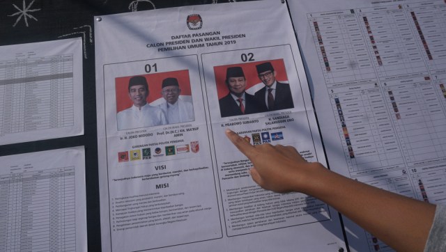 Seorang petugas menunjukkan surat suara di TPS bernuansa horor di Lebak Bulus, Jakarta, Rabu (17/4). Foto: Fanny Kusumawardhani/kumparan