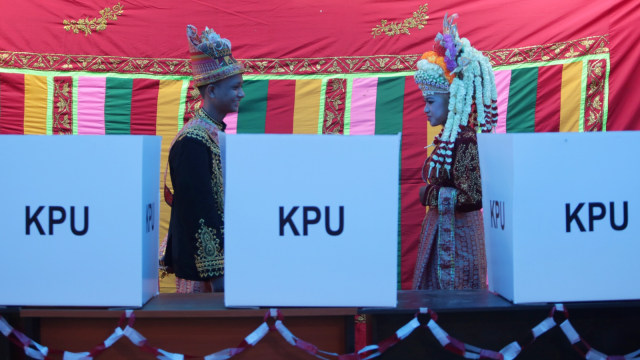 Petugas Kelompok Penyelenggara Pemungutan Suara (KPPS) memakai pakaian adat Aceh untuk melayani warga yang memberikan hak politiknya di Tempat Pemungutan Suara (TPS) Desa Naca, Trumon Tengah, Aceh Selatan, Aceh, Rabu (17/4). Foto: ANTARA FOTO/Irwansyah Putra
