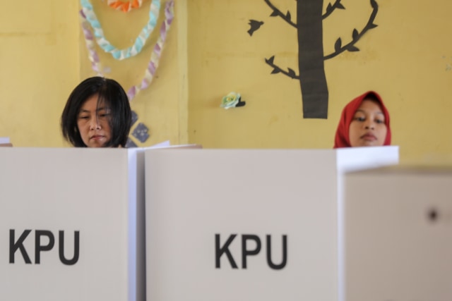 Dua warga Peunayong sedang melakukan pencoblosan di bilik suara, Rabu (17/4). Foto: Suparta/acehkini