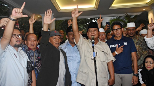 Paslon nomor urut 02, Prabowo-Sandi mengangkat tangan saat mendeklarasikan kemenangannya di kediaman Kertanegara. Foto: Antara/Indrianto Eko Suwarso
