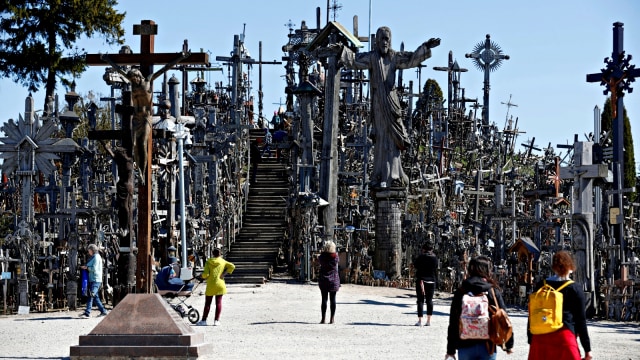 Pengunjung memasuki situs ziarah Bukit Salib di Siauliai, Lithuania jelang perayaan Paskah, Sabtu (20/4). Foto: Reuters/Ints Kalnins