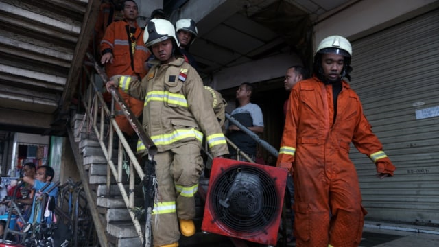 Petugas memadamkan kebakaran yang terjadi di pasar Tanah Abang, Jakarta,  Senin (22/4/2019). Foto: Irfan Adi Saputra/kumparan