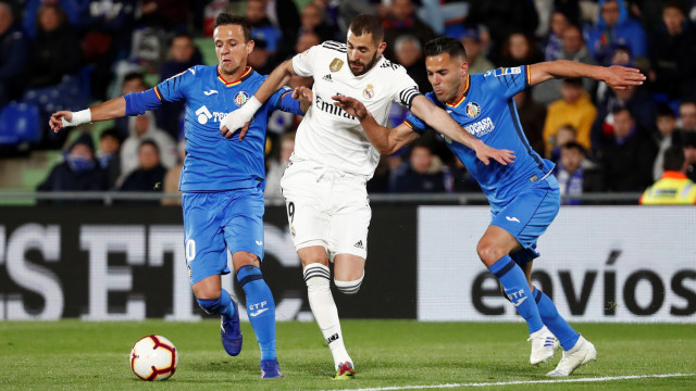 Benzema berusaha lolos dari kawalan dua pemain Getafe. Foto: REUTERS/Sergio Perez