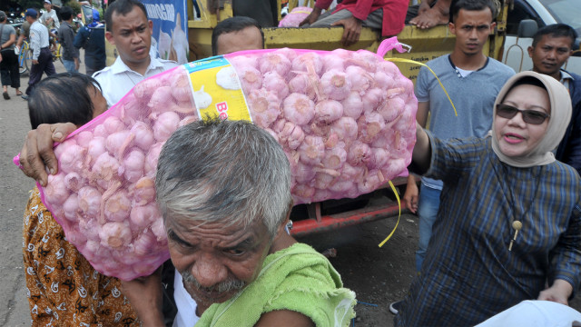 Inspektur Jenderal Kementerian Perdagangan Srie Agustina (kanan) mengecek bawang putih yang dibeli salah satu pedagang. Foto: ANTARA FOTO/Feny Selly