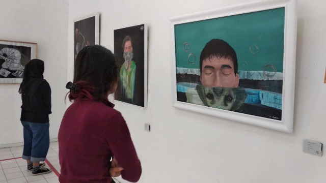 Sejumlah pengunjung melihat pameran lukisan yang digelar di Gedung Dewan Kesenian Malang.(foto: Ida/Tugu Malang).