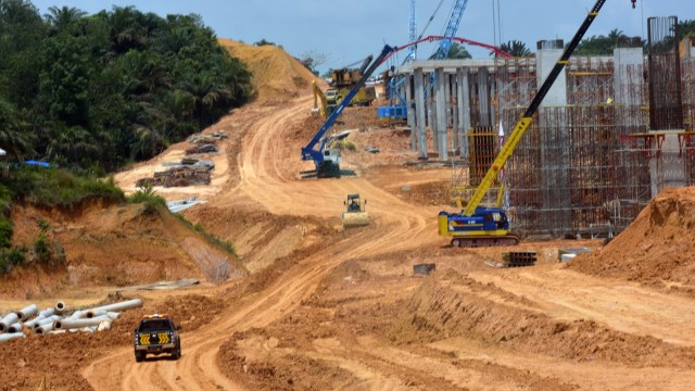 Sejumlah pekerja menggunakan alat berat untuk menyelesaikan proyek Jalan Tol Pekanbaru-Dumai Seksi 1, di Provinsi Riau, Selasa (30/4/2019). Foto: ANTARA FOTO/FB Anggoro