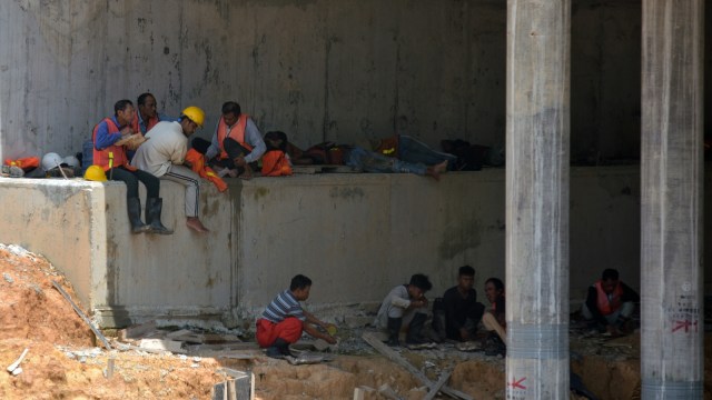 Sejumlah buruh beristirahat makan siang di bawah konstruksi jembatan di proyek Jalan Tol Pekanbaru-Dumai, Provinsi Riau, Selasa (30/4/2019). Foto: ANTARA FOTO/FB Anggoro